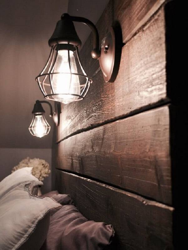 A cabeceira da cama recebeu um acabamento especial com madeira e luzes