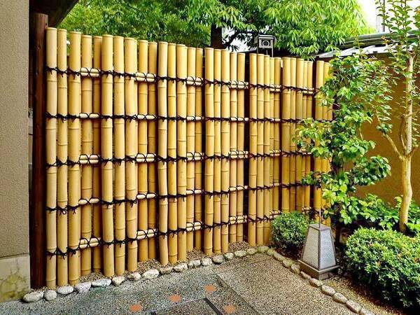 O artesanato com bambu grosso forma uma parede que confere privacidade ao ambiente