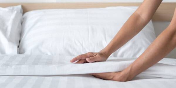 Opte por lençóis com elástico, pois assim eles ficam mais esticados na cama