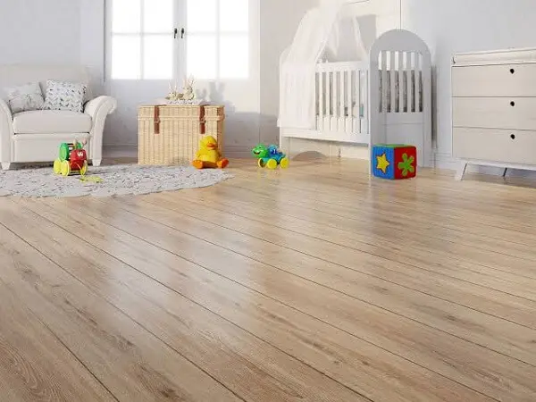O quarto de bebê recebeu o acabamento com piso flutuante de madeira