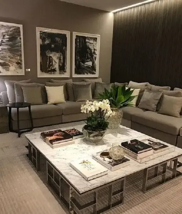 Sala de estar com sofá cinza e mesa de mármore