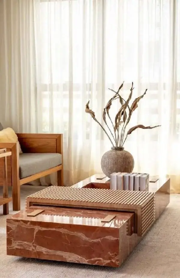 Sala de estar sofisticada com mesa de mármore e poltrona estofada