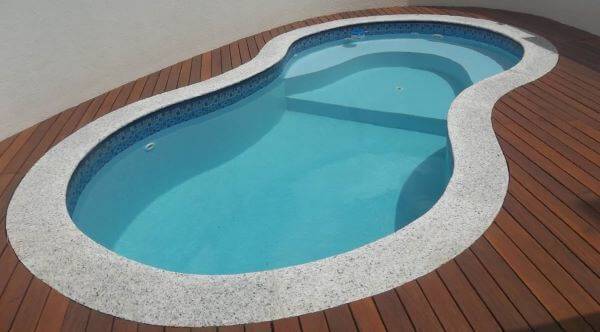 Borda de piscina com granito e madeira