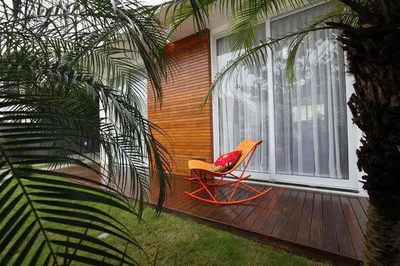 cor laranja - parede com tacos de madeira e cadeira metálica 