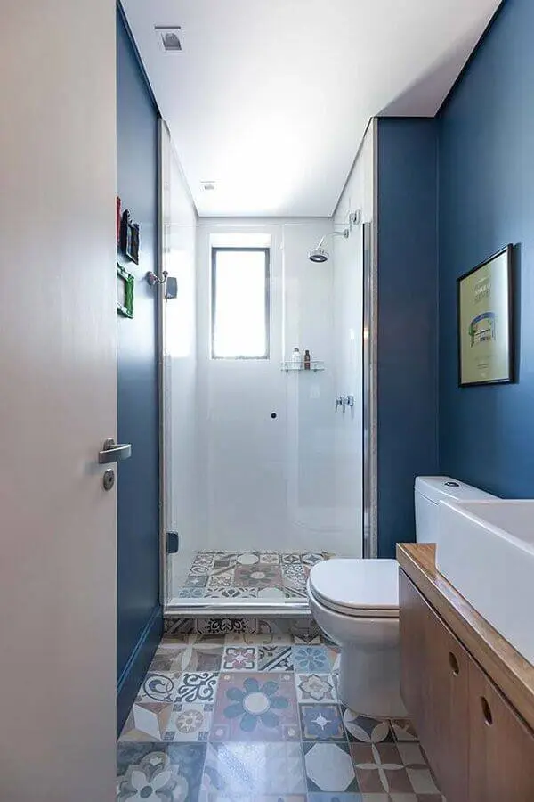 decoração banheiro pequeno planejado com piso hidráulico e gabinete de madeira Foto Revista VD