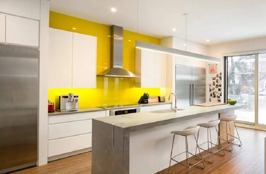decoração em branco e amarelo para cozinha conceito aberto com ilha de cimento queimado Foto Notey