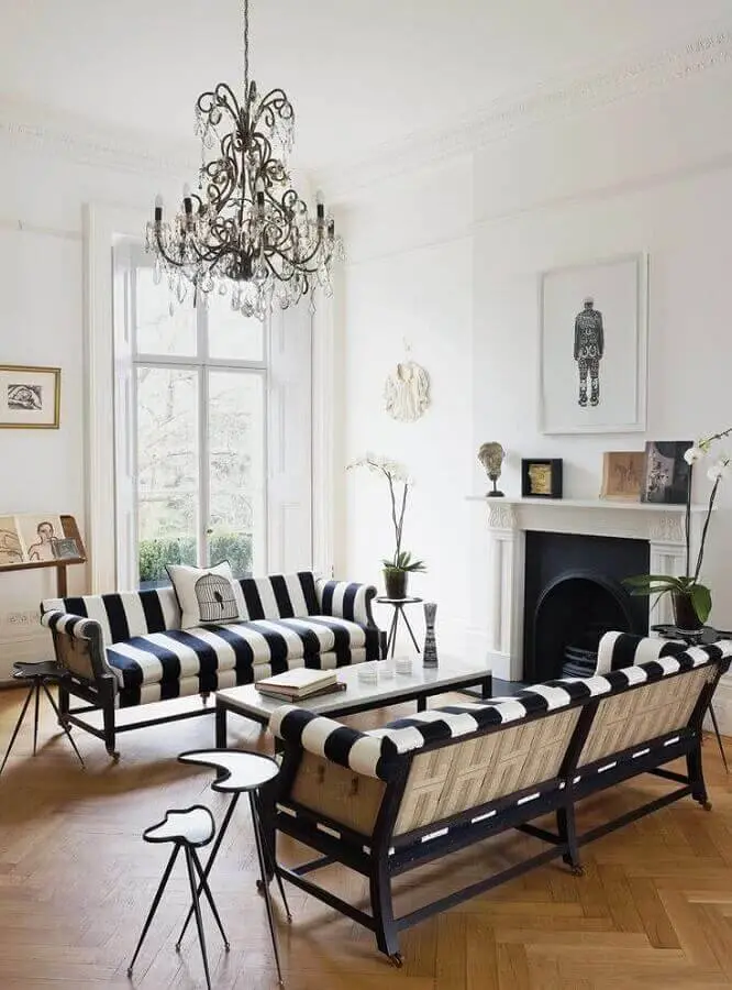 sala decorada com sofá listrado preto e branco e mesa de apoio diferente Foto Pinterest