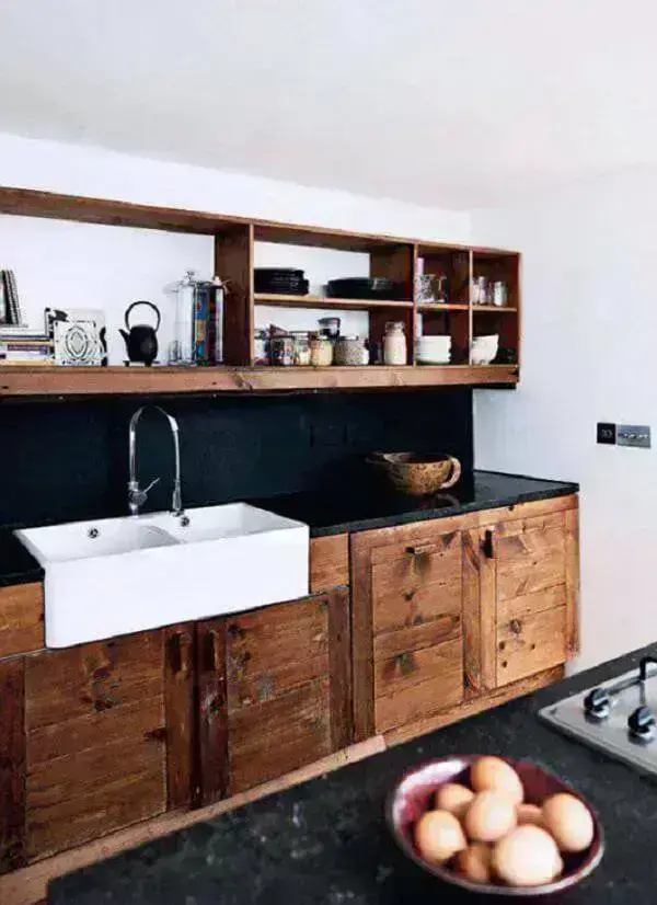 Armário de madeira maciça e bancada de granito preto complementam a decoração da cozinha