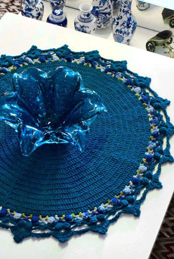 Centro de mesa de crochê redondo e azul com vaso da mesma cor
