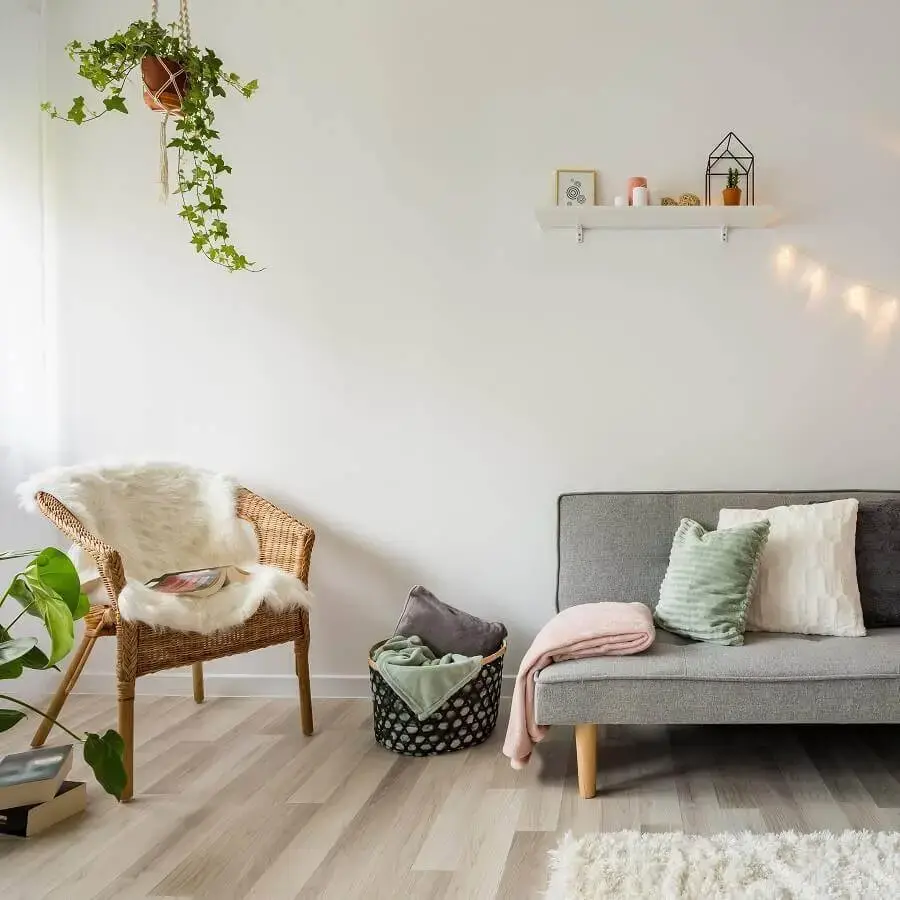 decoração minimalista para sala com sofá cinza e vasos de plantas