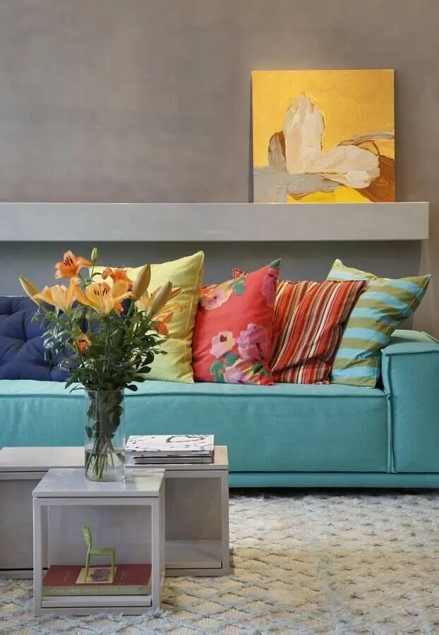 sala com parede cinza decorada com sofá azul e almofadas coloridas Foto Pinterest