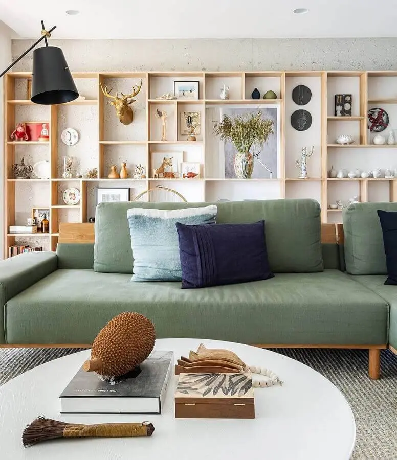 sofá verde moderno para decoração de sala com estante de madeira de nichos Foto Fernando Jaeger
