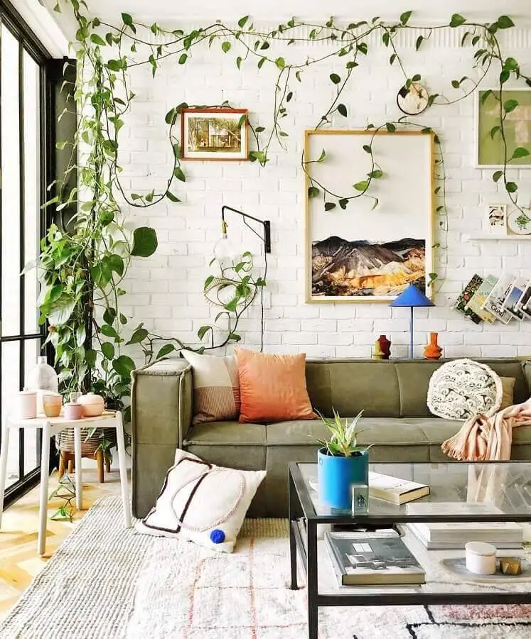 sofá verde musgo para sala decorada com parede de tijolinho e plantas Foto Jono Fleming