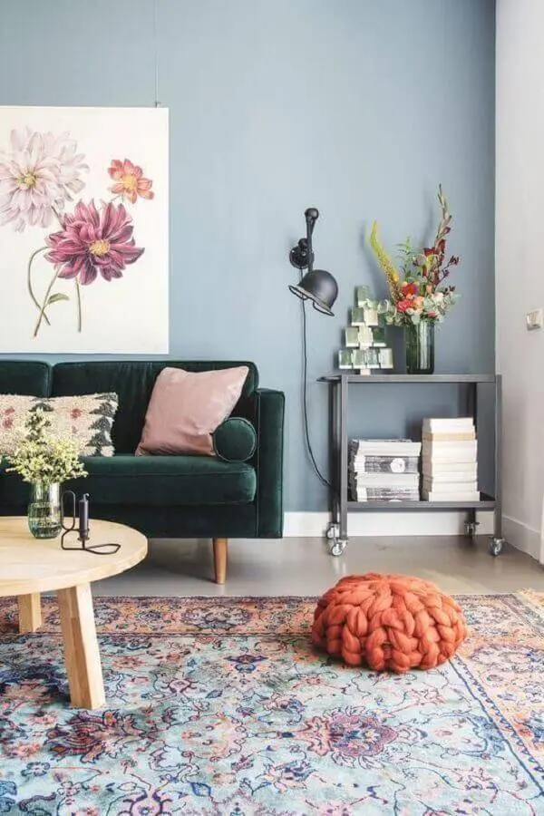 sofá verde para sala com parede azul clara e mesa de centro de madeira redonda Foto Ten is Extreme Shop