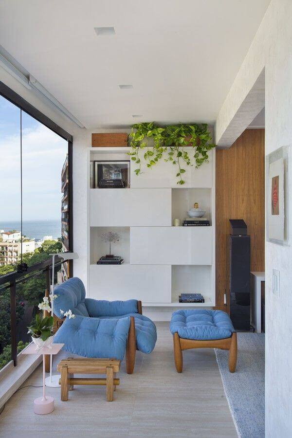 varanda de apartamento decorada com poltrona de madeira estofada azul  Foto Casa de Valentina