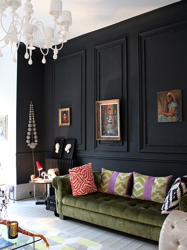 Sala de estar com parede preta e sofá capitonê de camurça