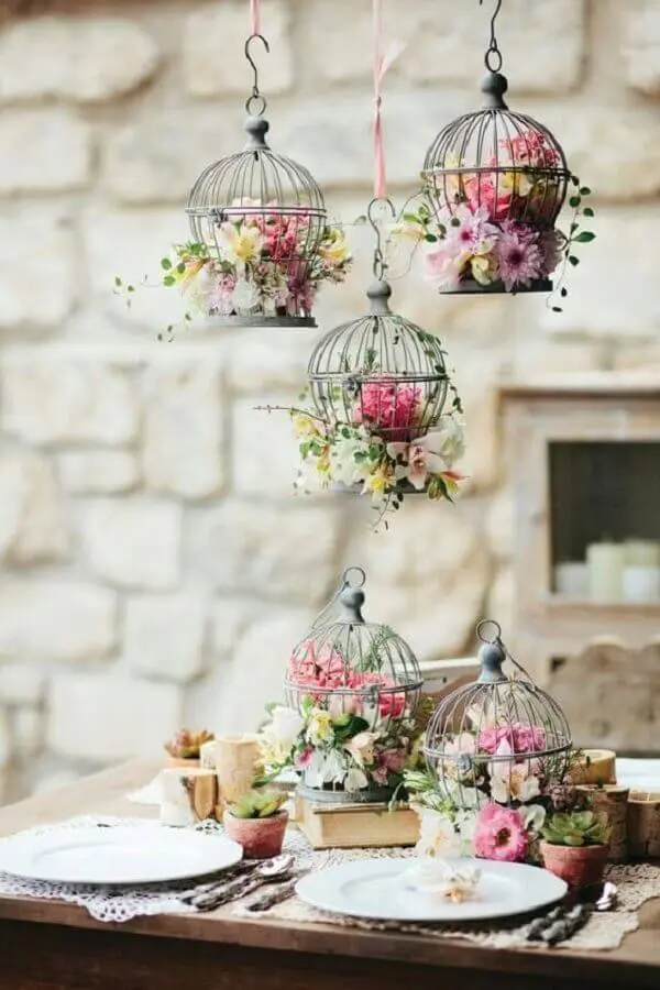 Decoração de aniversário de casamento com arranjos de flores dentro de gaiolas Foto Elle Decor