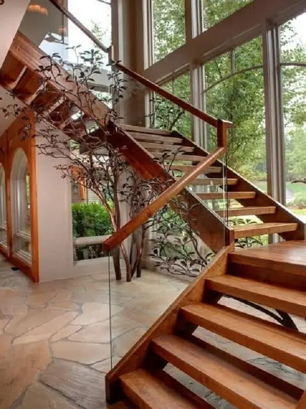 Escada de madeira com vidro traz aconchego para a decoração da casa