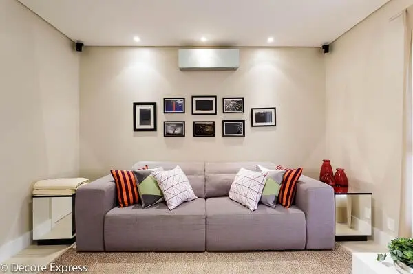 Sofá retrátil 2 lugares e almofadas coloridas decoram a sala de estar