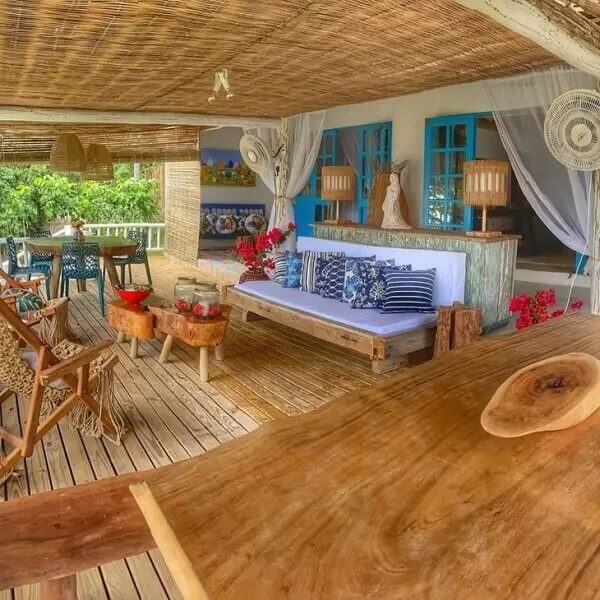 Teto com forro de palha e cadeira para varanda aberta de madeira. Fonte: Casa La Belle de Jour