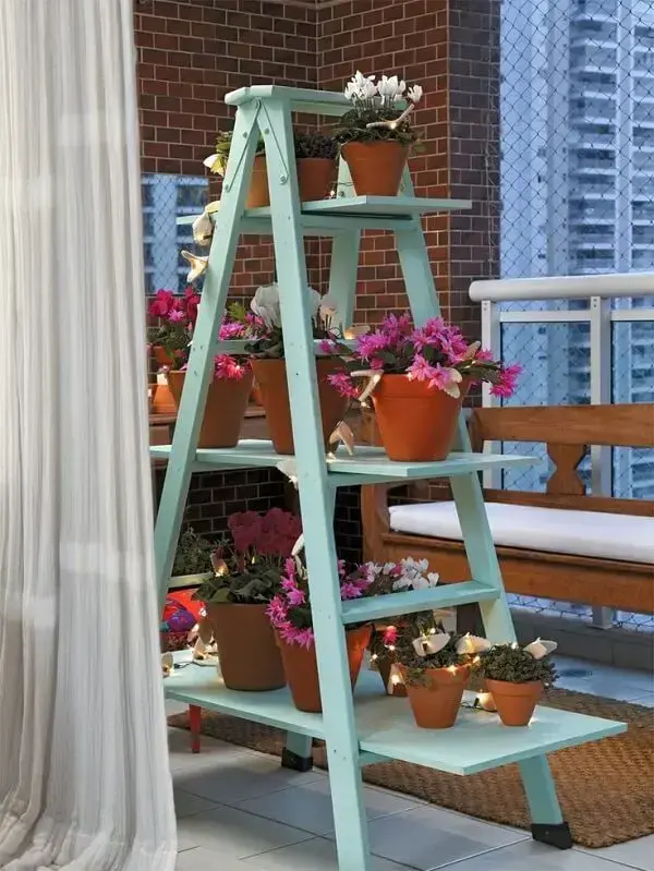 Floreira de madeira tipo escada serve de apoio para inúmeras plantas