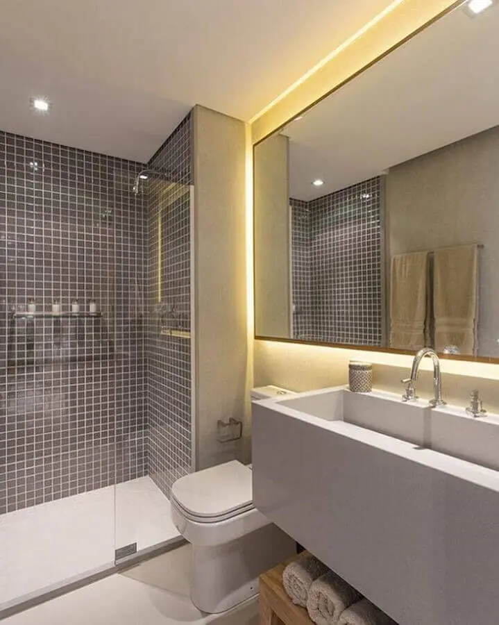 banheiro de apartamento moderno todo cinza decorado com pastilha e iluminação embutida no espelho Foto Sesso & Dalanezi Arquitetura