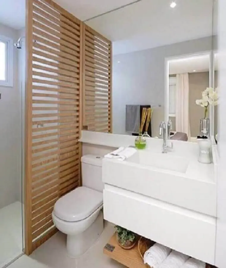banheiro de apartamento planejado decorado com divisória de madeira Foto D+ Arquitetura