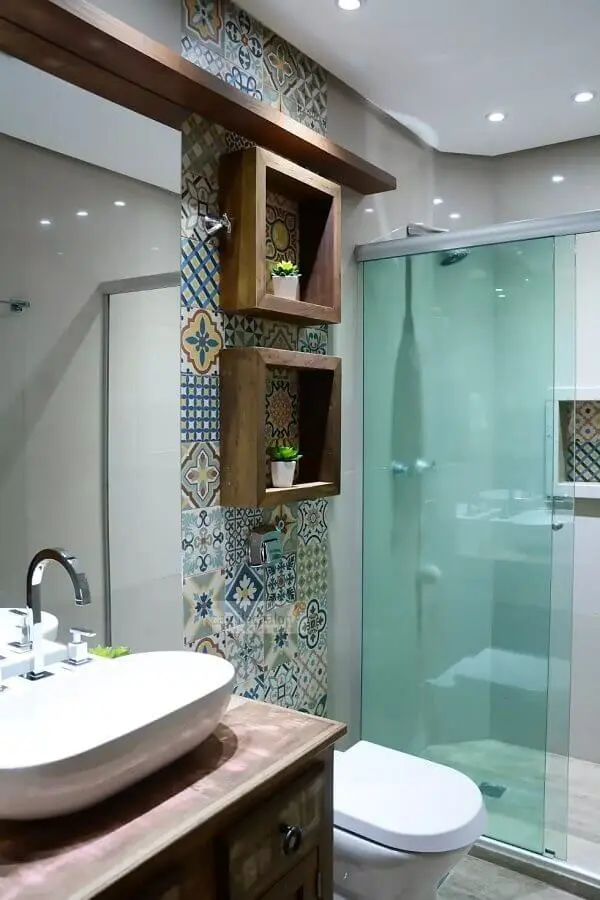 decoração banheiro de apartamento com azulejo hidráulico e nicho de madeira Foto Assetproject