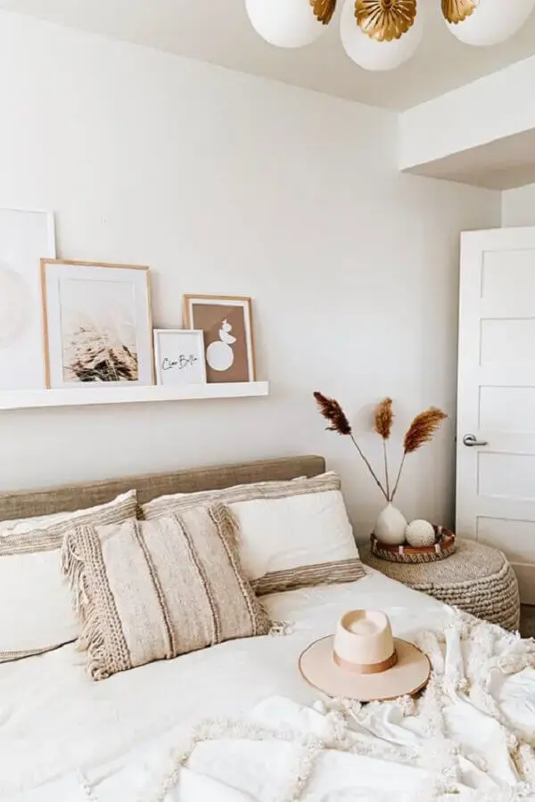 decoração em tons neutros para quarto de casal com quadros apoiados em prateleira Foto Article