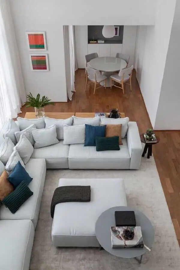 decoração moderna para sala com sofá de canto cinza com vários almofadas Foto Pinterest