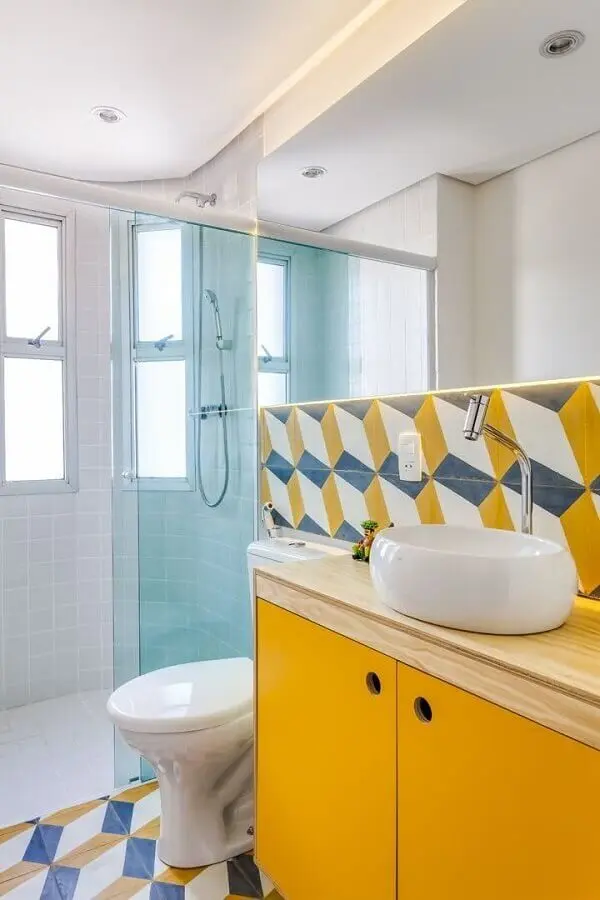decoração simples para banheiro de apartamento com gabinete amarelo e revestimento colorido Foto Construção & Design