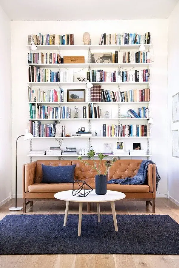 decoração simples para sala com estante de livros e sofá marrom Foto Architonic