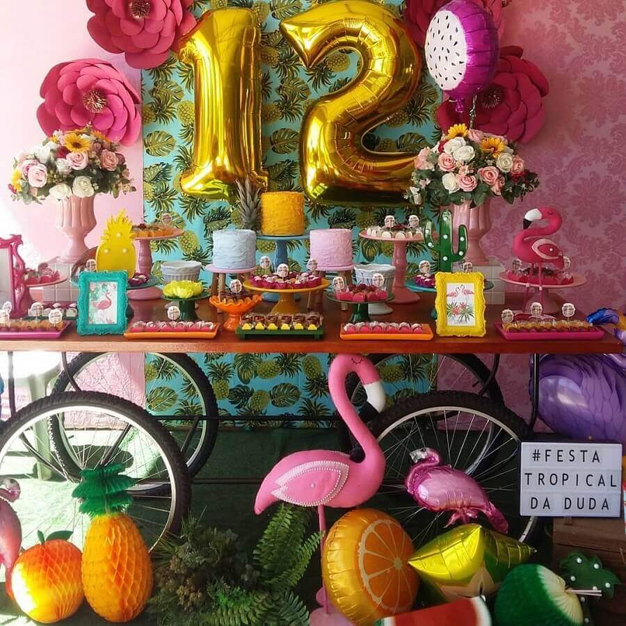 festa flamingo tropical decorada com pratos de doces coloridos e arranjo de rosas Foto Luart’s Festas
