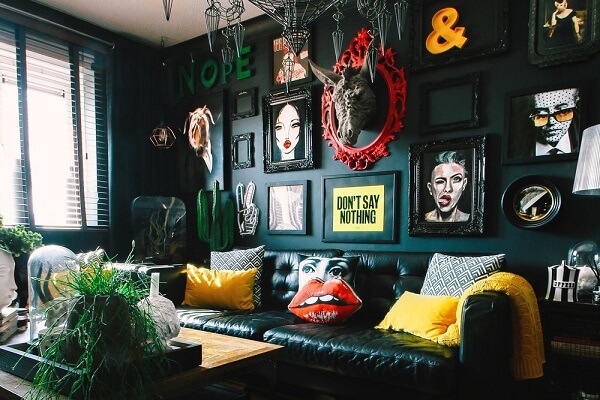 Transforme a decoração da sala com parede preta, quadros coloridos e sofá de couro