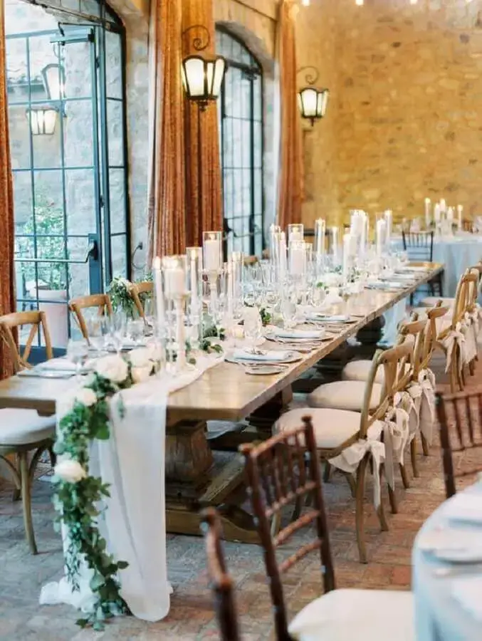mesa decorada com folhagens rosas brancas e velas para aniversário de casamento Foto Glamour & Woods