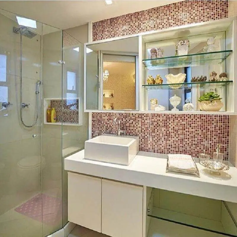 modelo de banheiro de apartamento decorado com armário suspenso e pastilhas rosa Foto LM Arquitetura