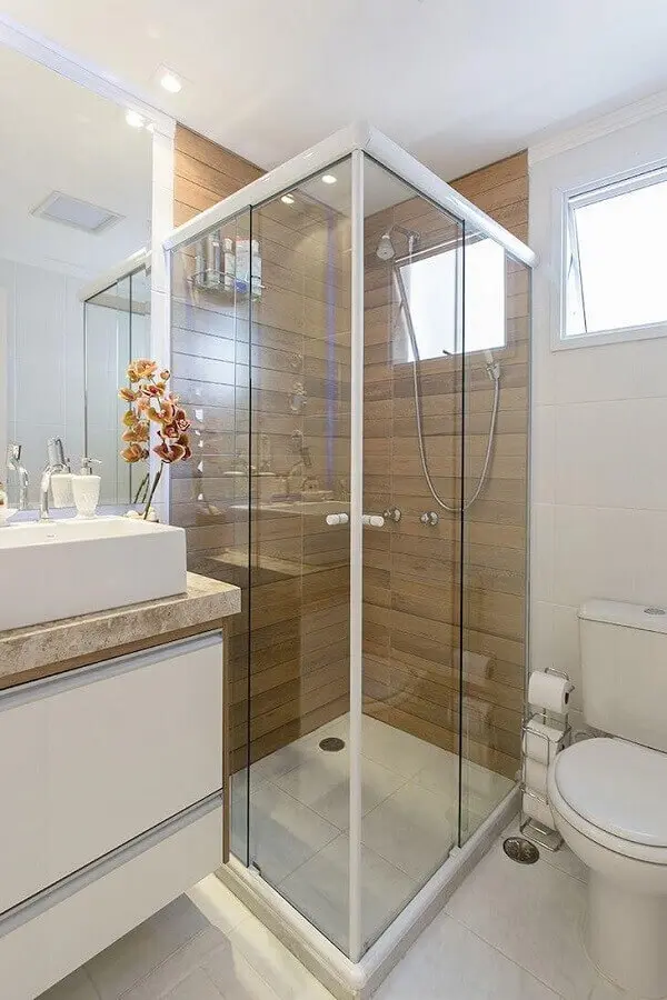 modelo de banheiro de apartamento decorado com porcelanato que imita madeira na área do box Foto LO Interiores