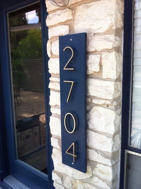 Número de casa com placa azul e números em inox