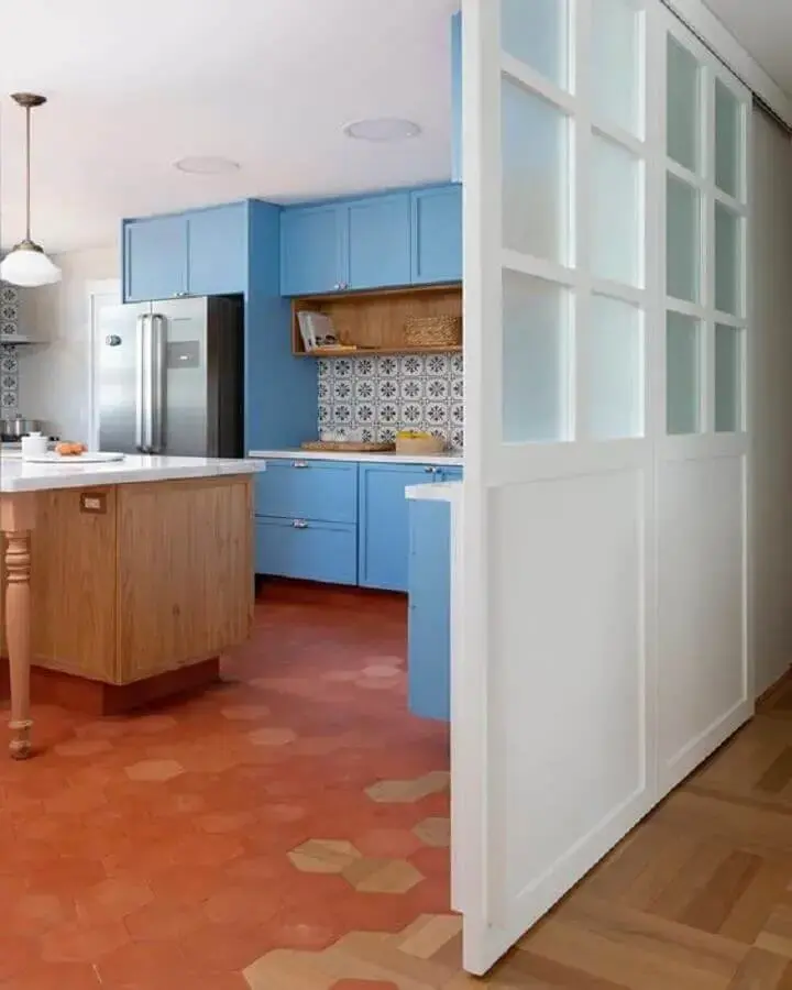 piso na cor terracota para cozinha decorada com armários azuis Foto Pinterest