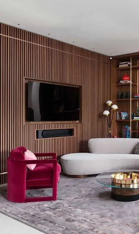 poltrona rosa magenta para decoração de sala moderna com sofá cinza e painel de madeira Foto Homedit