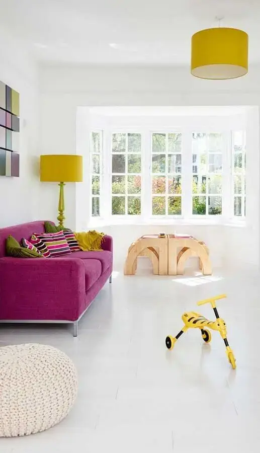 sala de estar toda branca decorada com sofá magenta e abajur amarelo Foto Pinterest