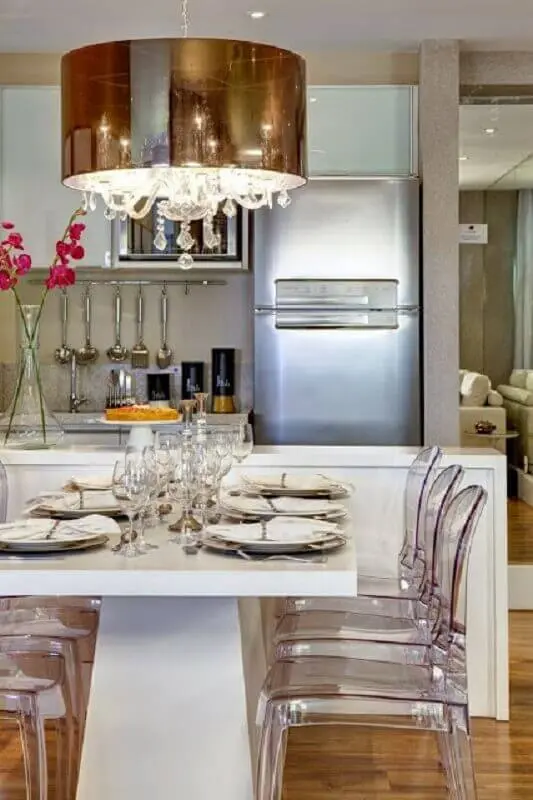 sala de jantar moderna toda branca com lustre pendente cobre e cadeiras de acrílico transparente Foto Otimizi