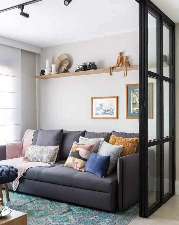 sala simples decorada com sofá cinza e almofadas coloridas Foto Duda Senna