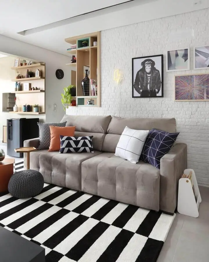 sofá cinza para decoração de sala com parede de tijolinho branca e tapete listrado preto e branco Foto Bianchi & Lima Arquitetura