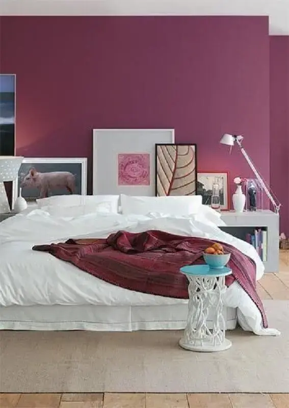 tinta magenta para decoração de quarto com vários quadros decorativos Foto Assetproject