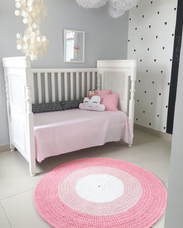 Quarto de bebê clean com tapete rosa redondo