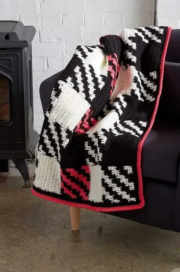 A manta colorida feito em crochê tunisiano trouxe vida ao sofá preto