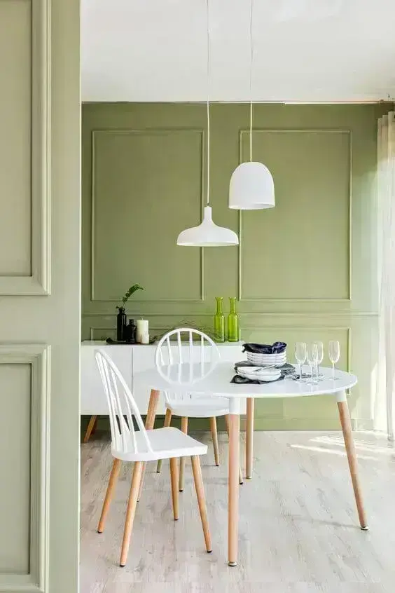 A parede verde traz personalidade para a sala de jantar com móveis brancos - Fonte: Arkpad