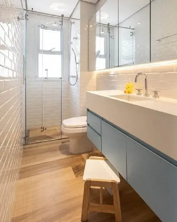 Ambiente decorado com cerâmica para banheiro metro white e gabinete azul. Fonte: Marina Carvalho