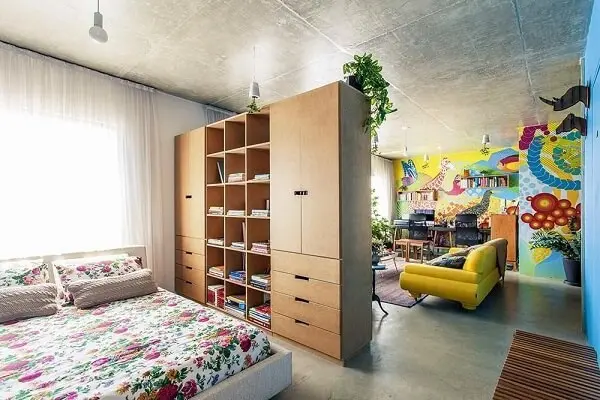 Armário de madeira, parede com pintura colorida e sofá amarelo